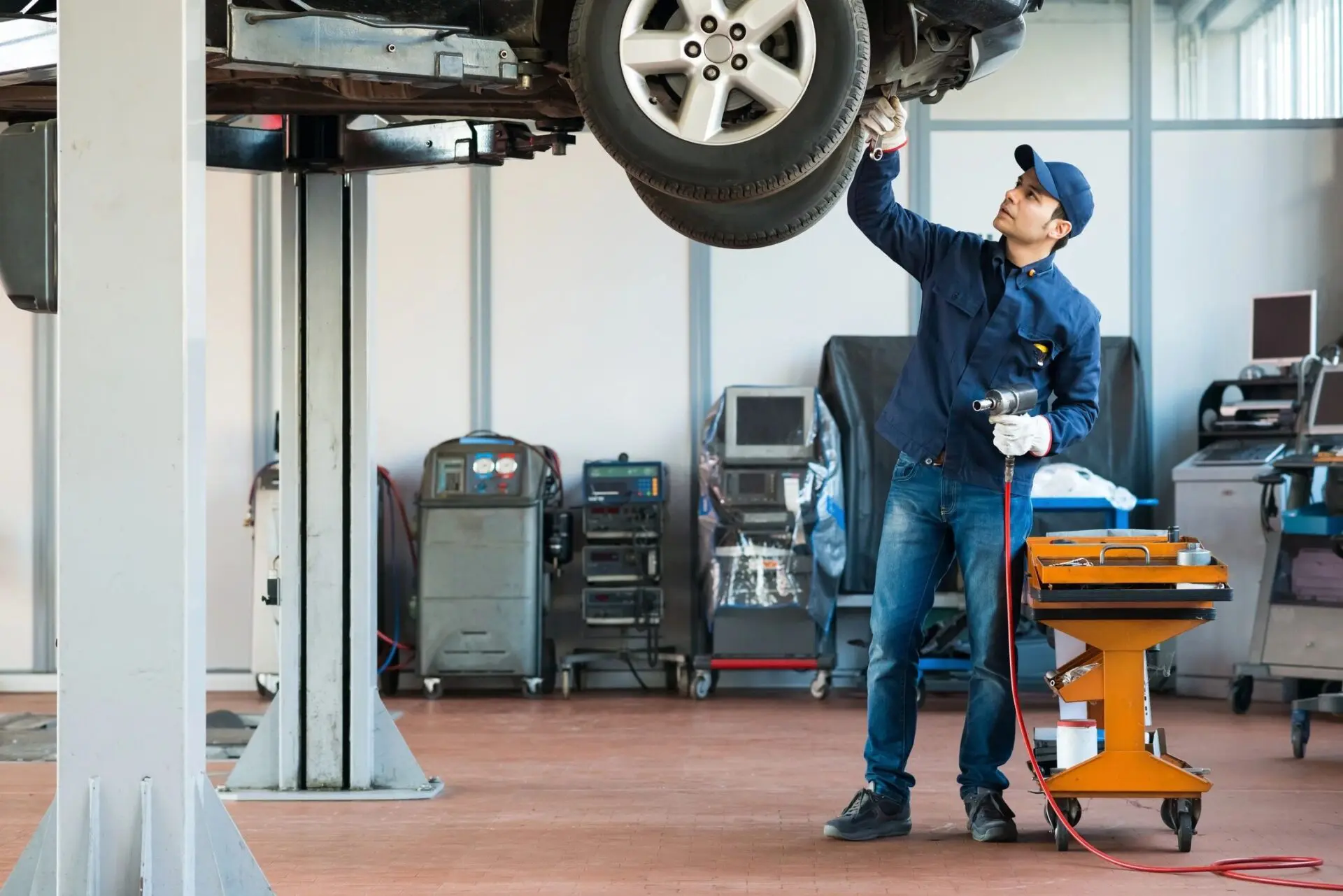 A man working on a car in a garage.