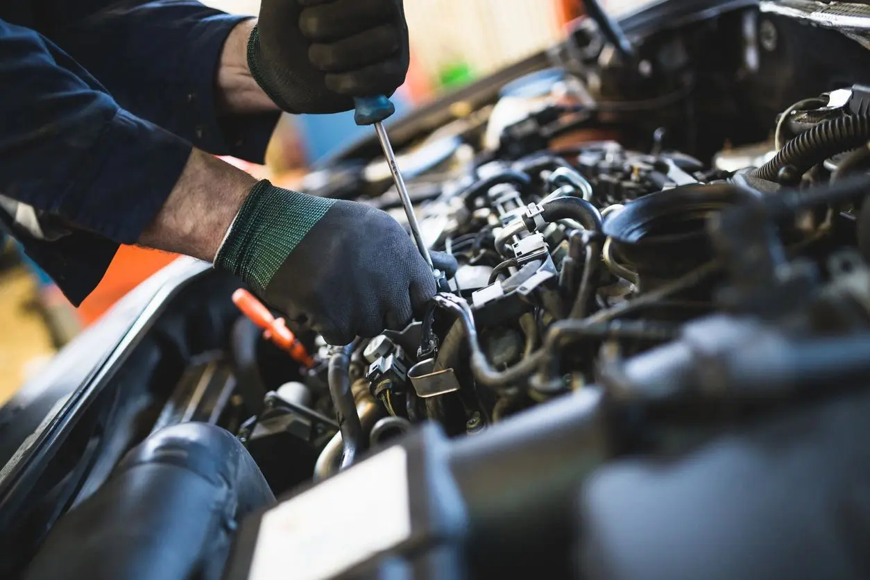 A person working on an engine in a garage.