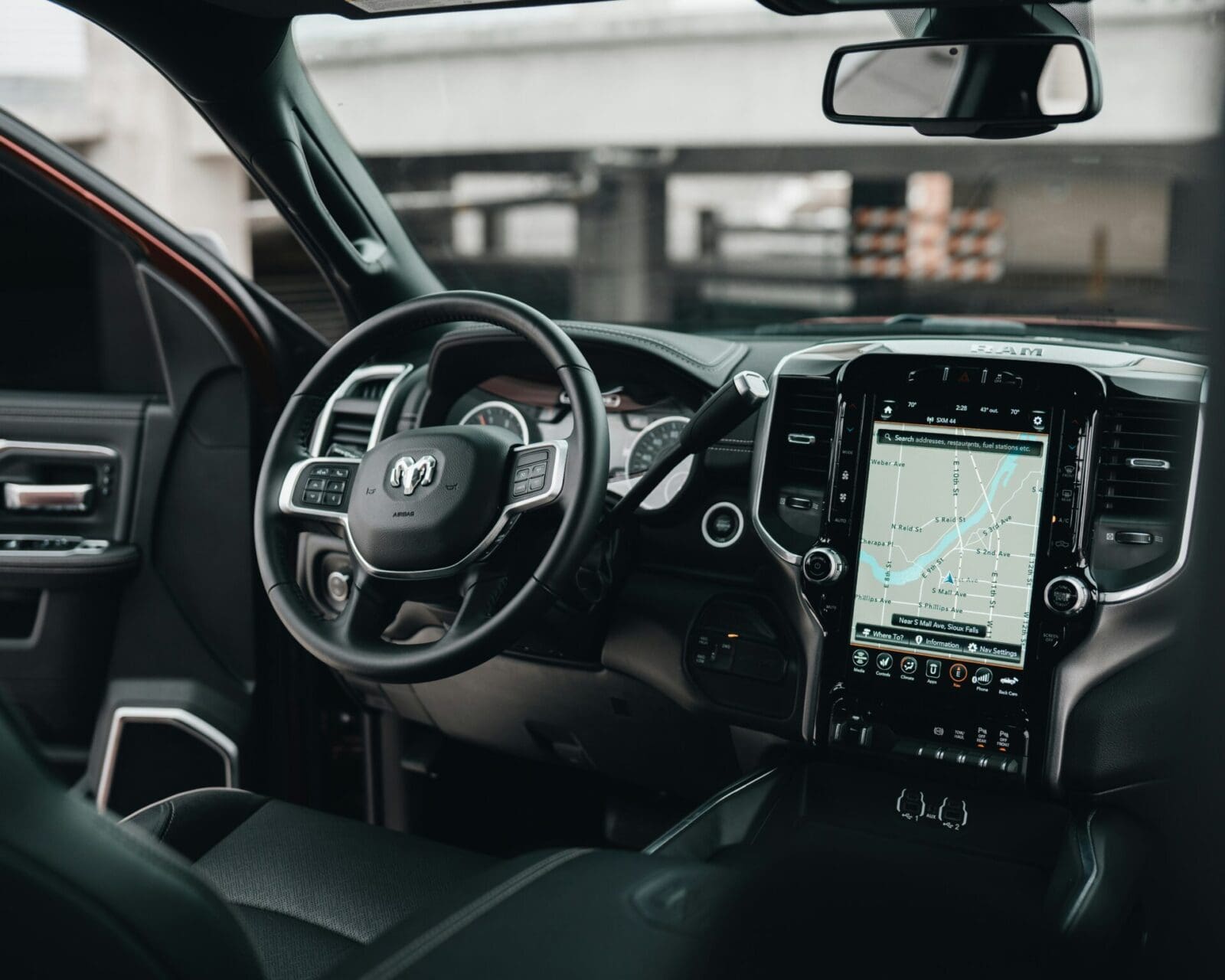 A car dashboard with the steering wheel and dashboard lights on.